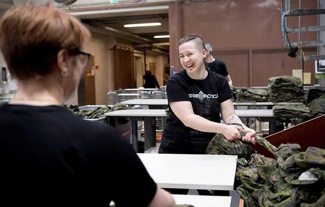 Maria Lehtonen ja Johanna Vehviläinen viikkaavat maastopukuja.