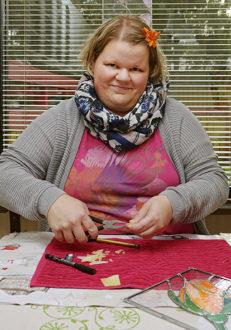 Tiina Stengård klipper ut pappersbitar att använda som modell när hon skär ut glas. Fotograf: Linda Varoma