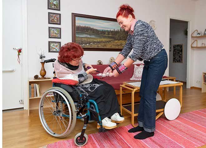avustaja ja avustettava sytyttävät tuikkukynttilöitä yhdessä