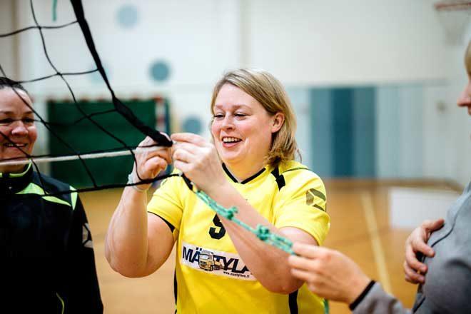 Milla Leino fäster volleybollnätet inför matchen.