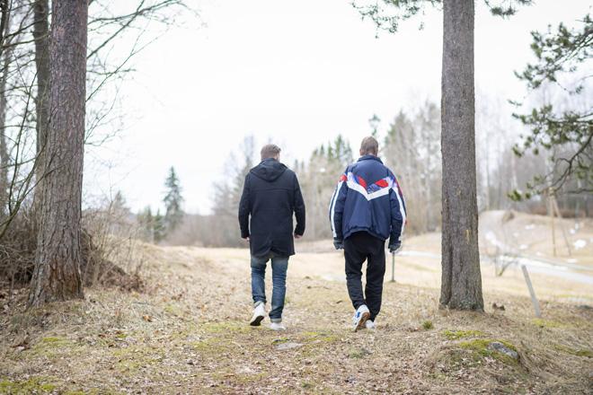 kaksi miestä kävelee luonnossa