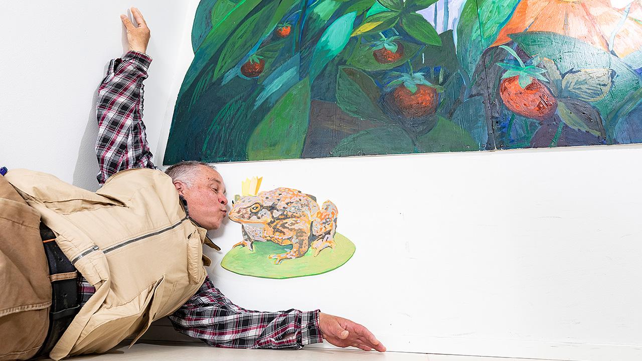 Taiteilija Pekka Kainulainen suutelee piirrossammakkoa