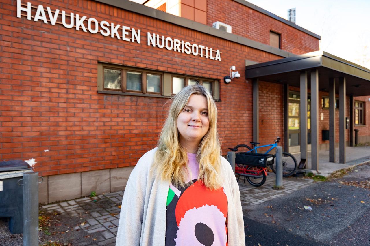 Nuoriso-ohjaaja, ammattiliittoaktiivi Lotta Kuismanen hymyilee työpaikkansa Havukosken nuorisotilan pihalla.