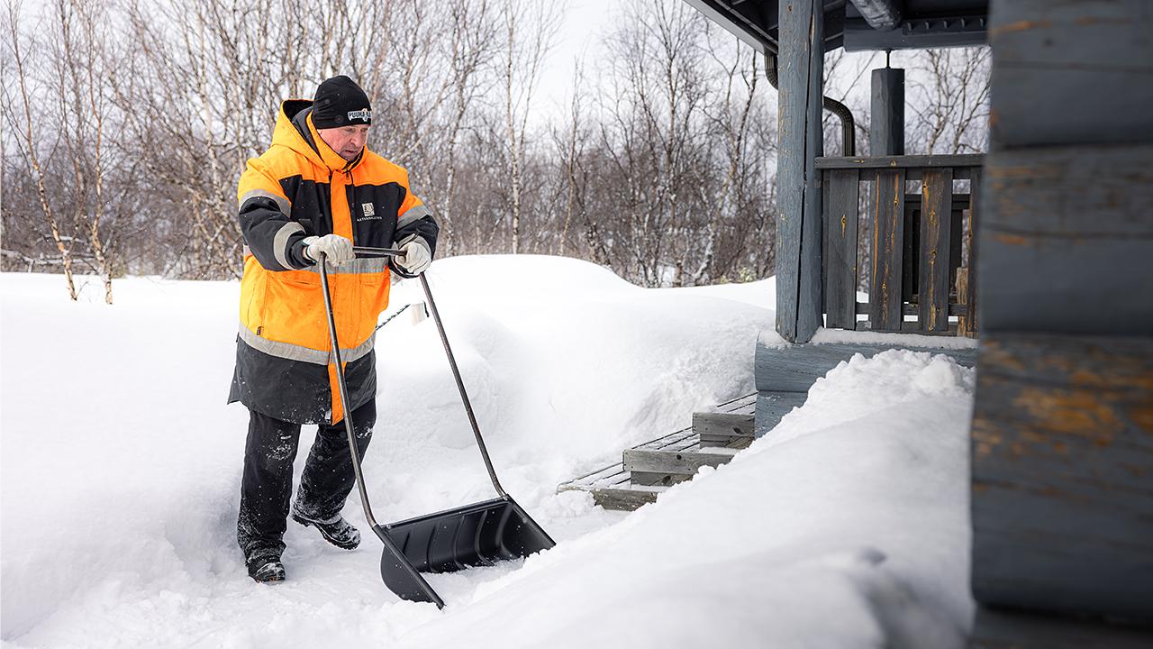 Kenttämestari Martti Kyro lapioi lunta Karigasniemellä hangessa.