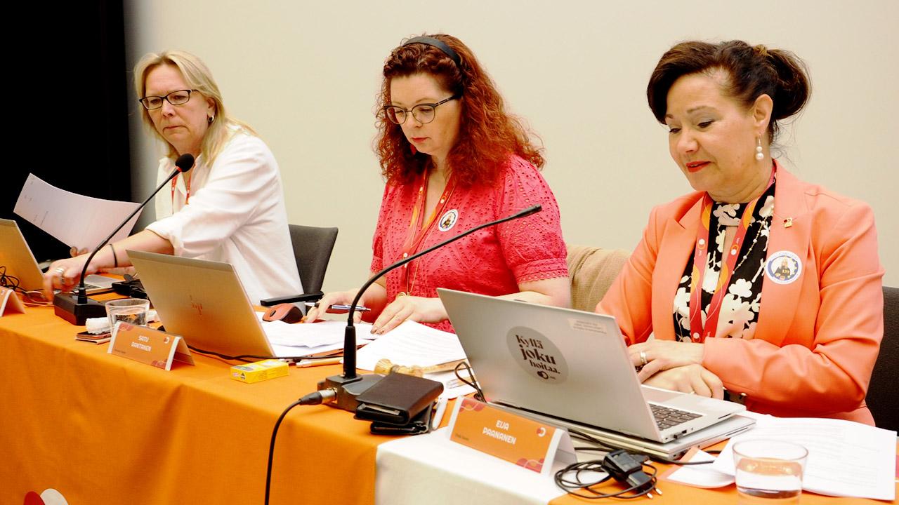 JHL:n edustajiston puheenjohtajakolmikko Tiina Liimatainen, Satu Rantanen ja Eija Paananen istuu pöydän ääressä.