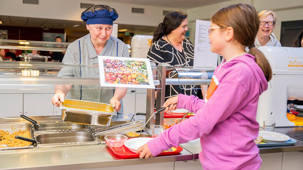 Lapsi saa kasvisruokaa Ollikkalan koulun ruokalassa Salossa.