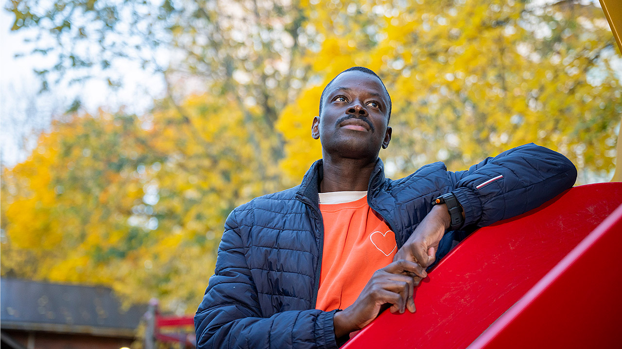 Esiopettaja Paco Diop nojaa liukumäkeen koulun pihalla.