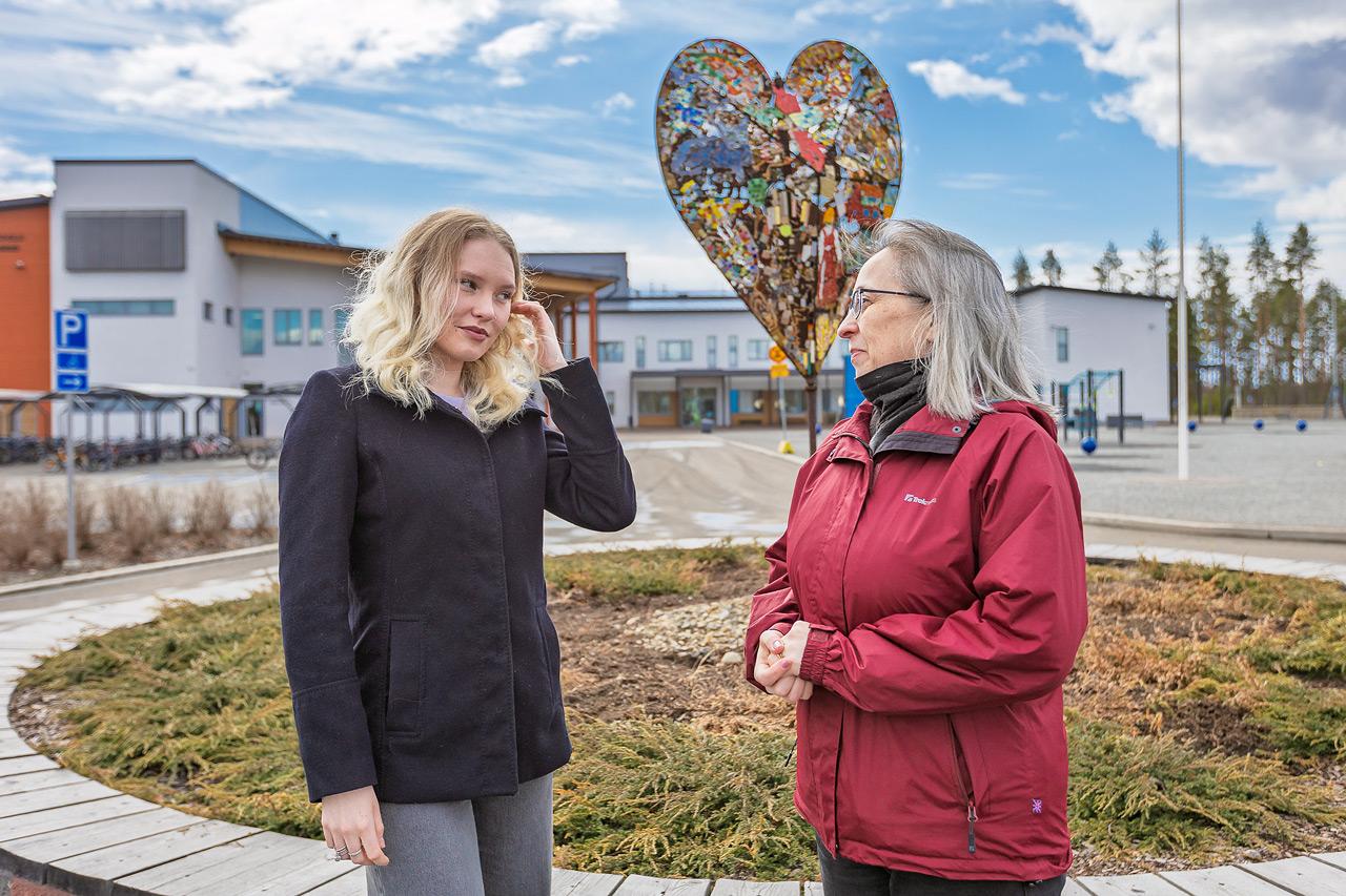 Työpaikkaohjaaja Niina Joronen ja ohjattava Sanni Hyvärinen seisovat Ylämyllyn koulun pihalla.