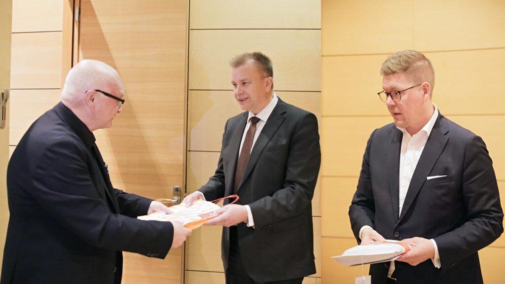 JHL:n puheenjohtaja Håkan Ekström luovuttaa sammutuspeiton keskustan puheenjohtaja Antti Kaikkoselle ja sdp:n puheenjohtaja Antti Lindtmanille.