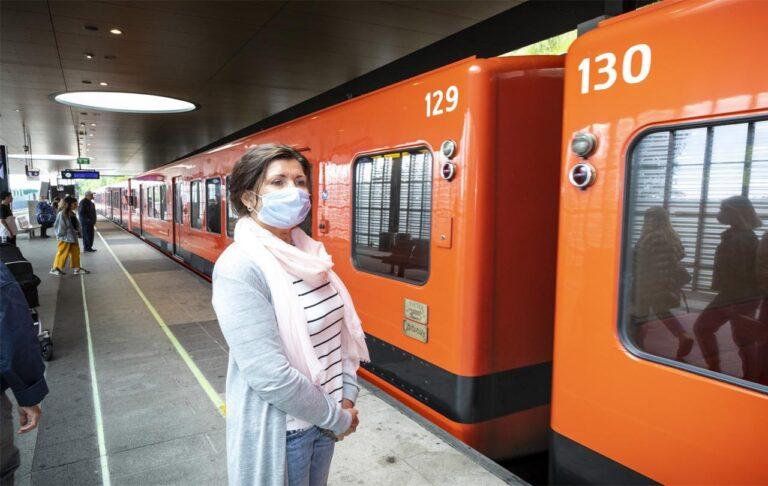 nainen metroasemalla maski kasvoilla