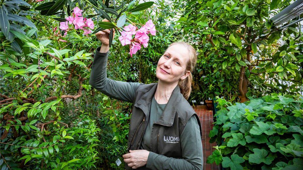 Puutarhuri Pirkitta Puustinen esittelee kukkia Kaisaniemen kasvitieteellisessä puutarhassa.