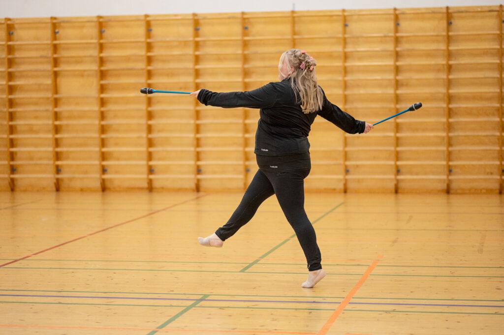 Erityisvoimistelija Emilia Aherikko treenaa liikuntasalissa.