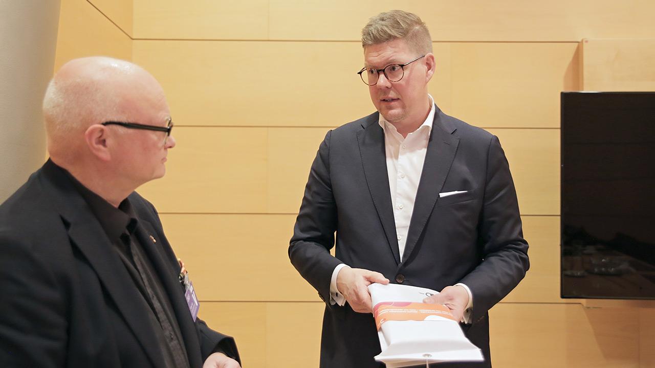 JHL:n puheenjohtaja Håkan Ekström luovuttaa sammutuspeiton sdp:n puheenjohtaja Antti Lindtmanille.