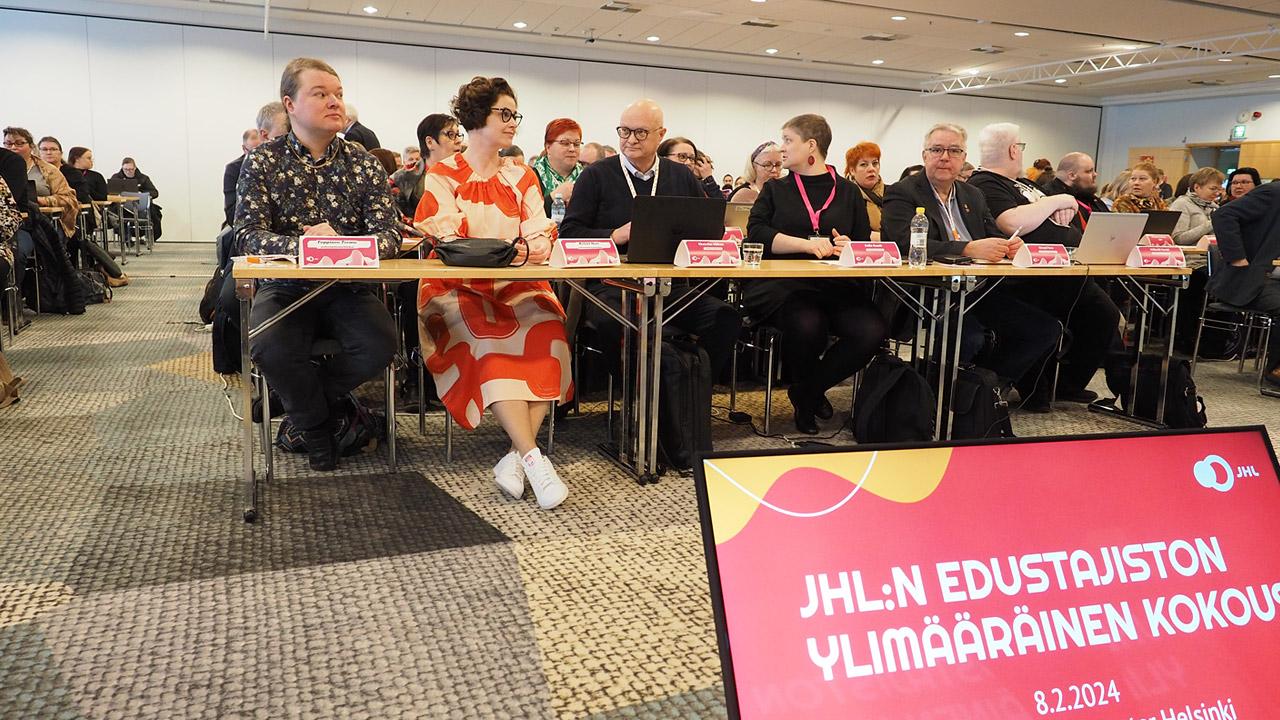 Ihmisiä istumassa seminaarihuoneessa riveissä.