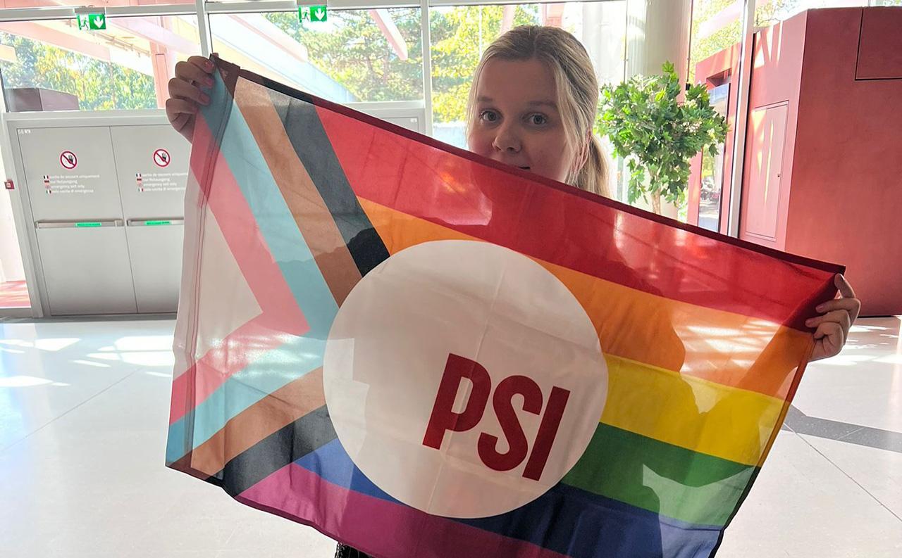 Nuoriso-ohjaaja, ammattiliittoaktiivi Lotta Kuismanen pitelee sateenkaarilippua.