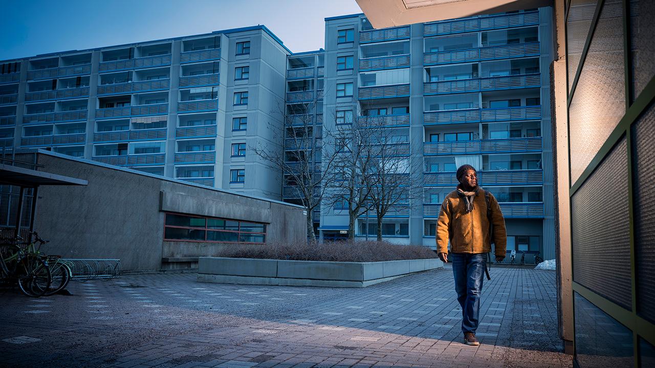 Kotihoidon lähihoitaja Percy Mashaire kävelee kerrostalokorttelissa.