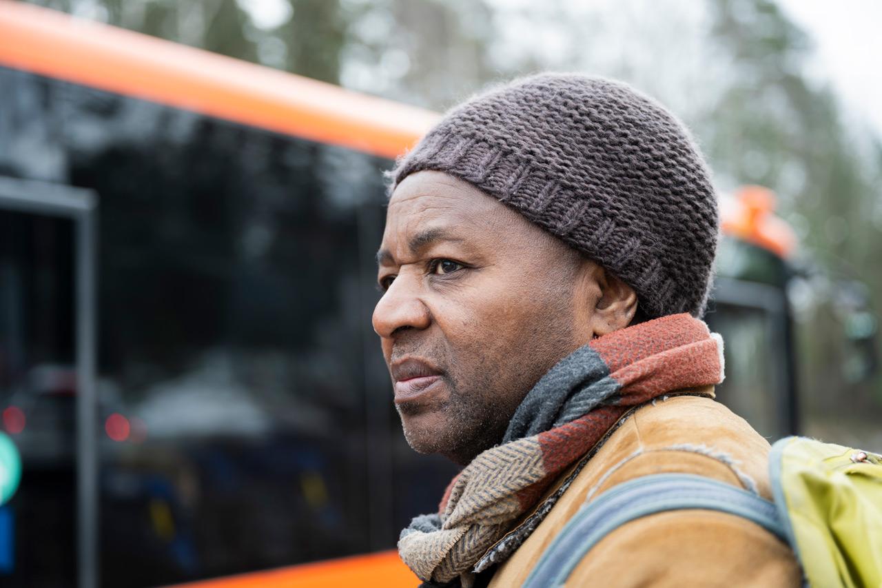 Kotihoidon lähihoitaja Percy Mashaire odottaa bussipysäkillä bussia töihin.