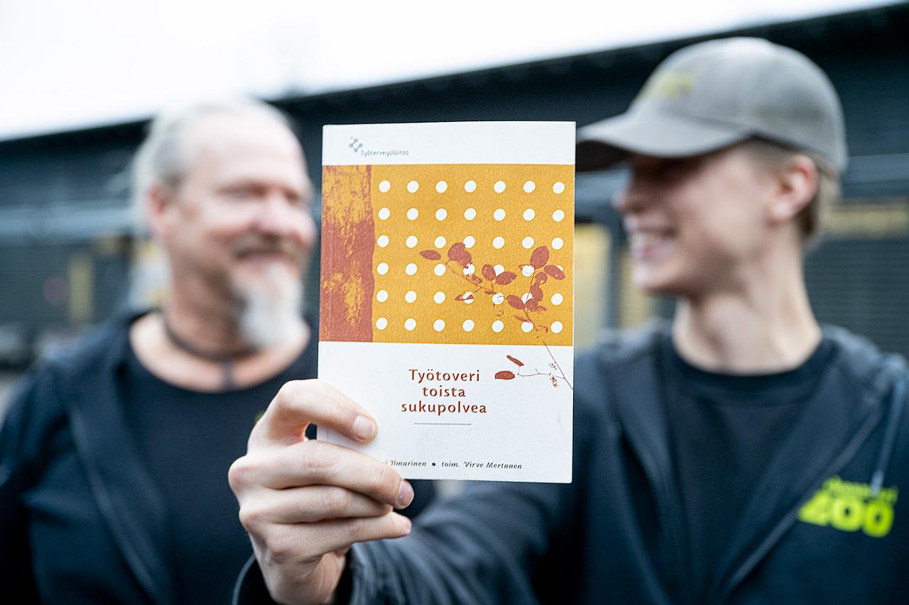 Korkeasaaren aluehuoltajat Ray Majander ja Wiljami Kaskimies näyttävät kirjaa.