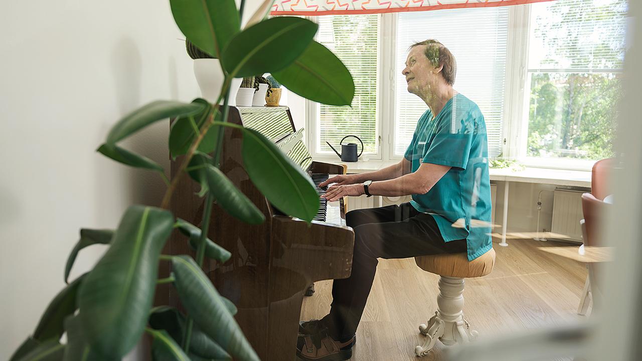 En vårdare spelar piano.