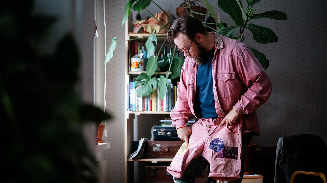 Varhaiskasvatuksen opettaja, käsityöaktivisti Niko Lindgren parsii farkkuja kotonaan.