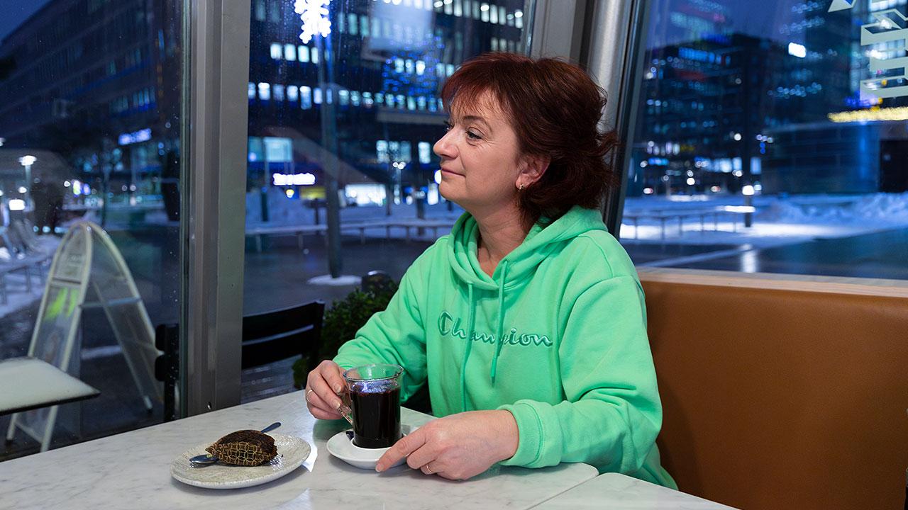 Koulunkäynninohjaaja Elvira Ansas istuu pöydän ääressä kahvilassa ja juo glögiä.