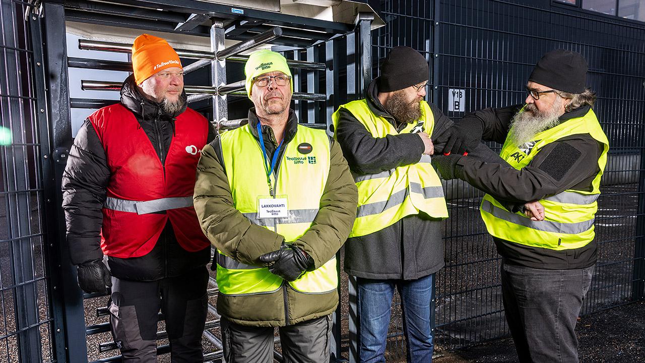 Neljä huomioliiviin pukeutunutta lakkovahtia seisoo Vuosaaren satamassa.