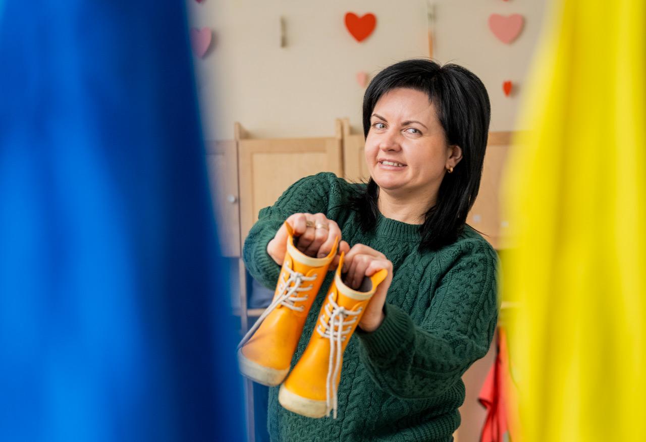 Yehveniia Darmostuk pitää keltaisia saappaita käsissään