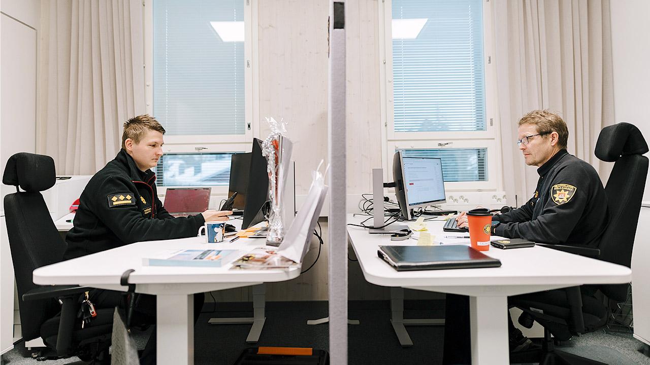 Palopäällikkö Kalle Lantta ja palotarkastaja Tauno Niemi istuvat työhuoneessa Lappeenrannan paloasemalla.