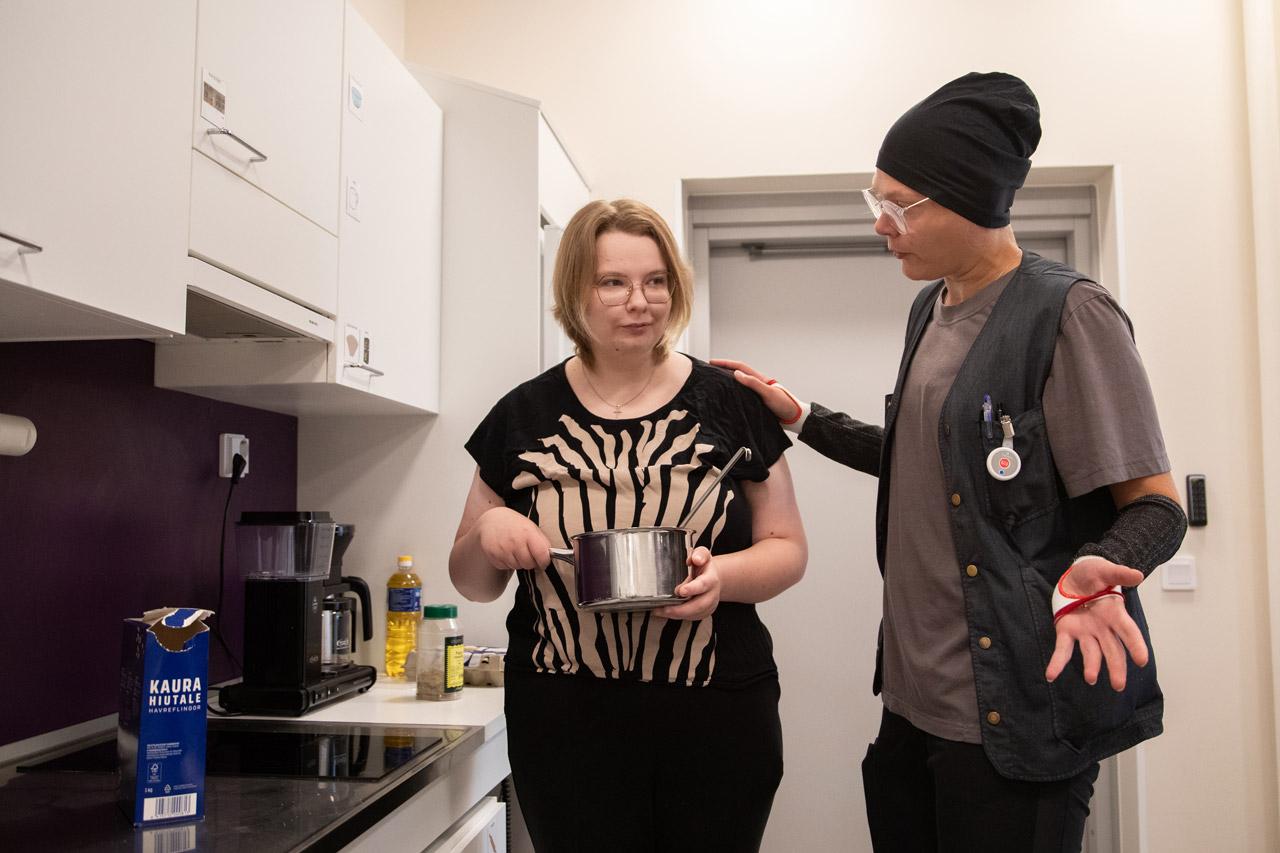 Palvelukeskus Konstin keittiössä voi harjoitella arjen askareita. Puuronkeittovuorossa sairaanhoitaja Roosa Sarajärvi (vas.) ja asiakas Miia Argillander. Sarajärvellä on kädessään turvahiha.   