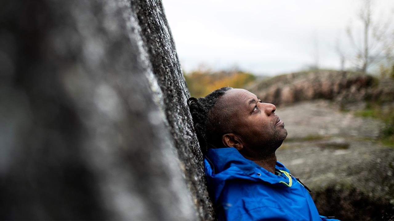 Kotihoitaja Percy Mashaire nojaa puuhun Helsingin Alppipuistossa.