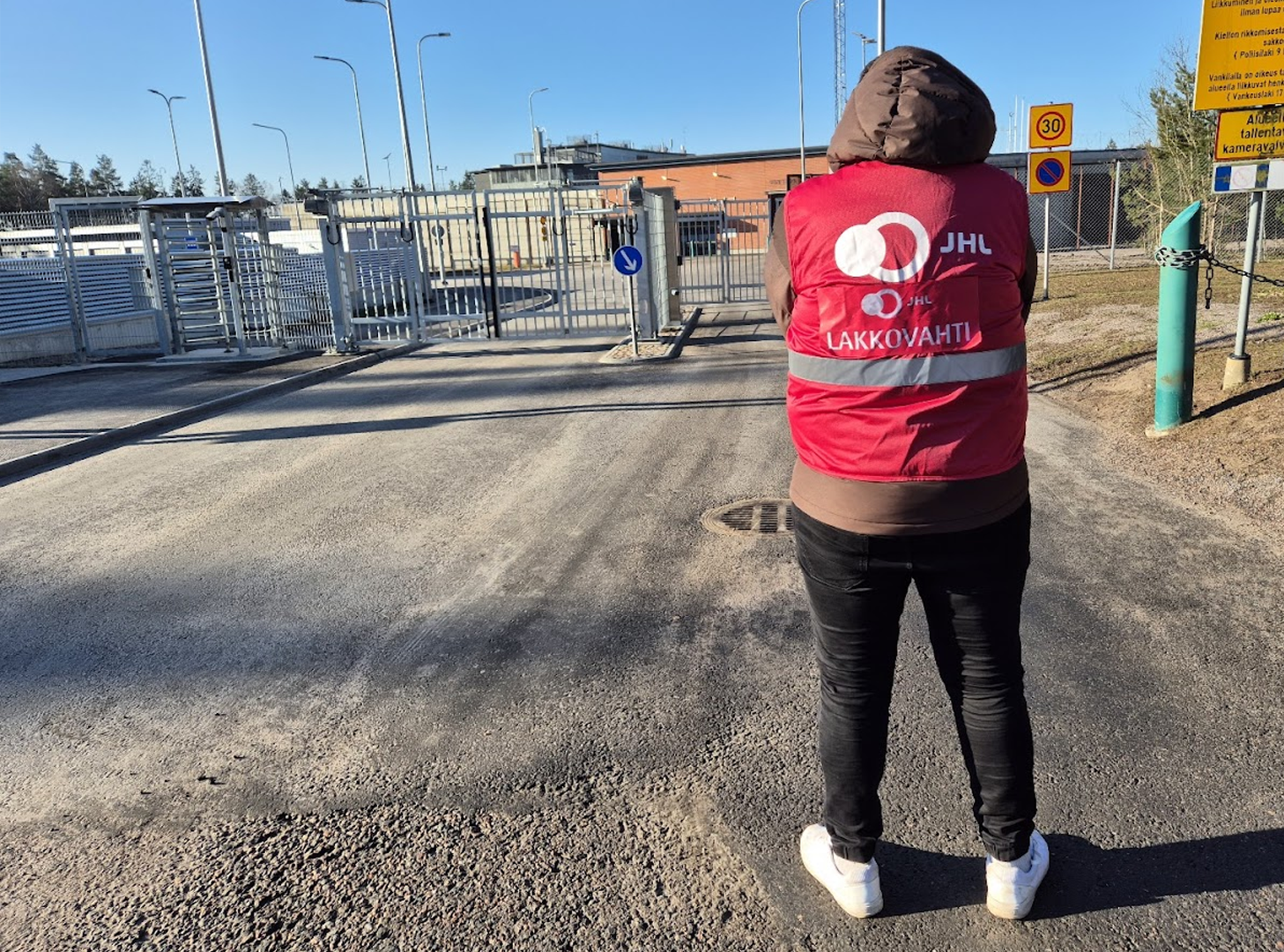 Lakkovahti seisoo selin kameraan Vantaan vankilan edustalla valtion lakkopäivänä.