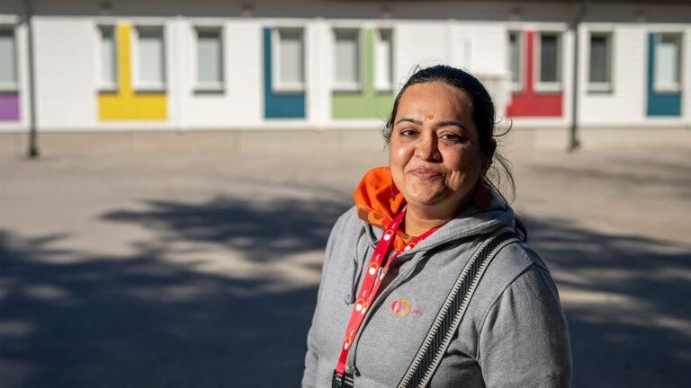 koulunkäynninavustaja Priya Gidwani katsoo kameraan Turku Lausteen koulun pihalla. Jäsen numeroina.