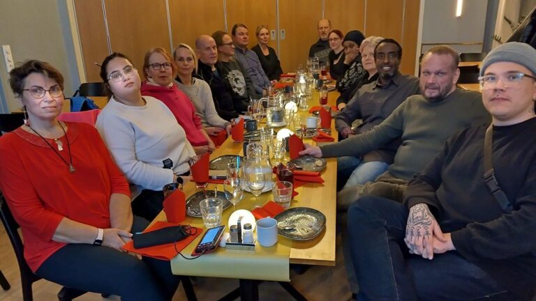The board of JHL ry 141 sitting at a long table in their first meeting.