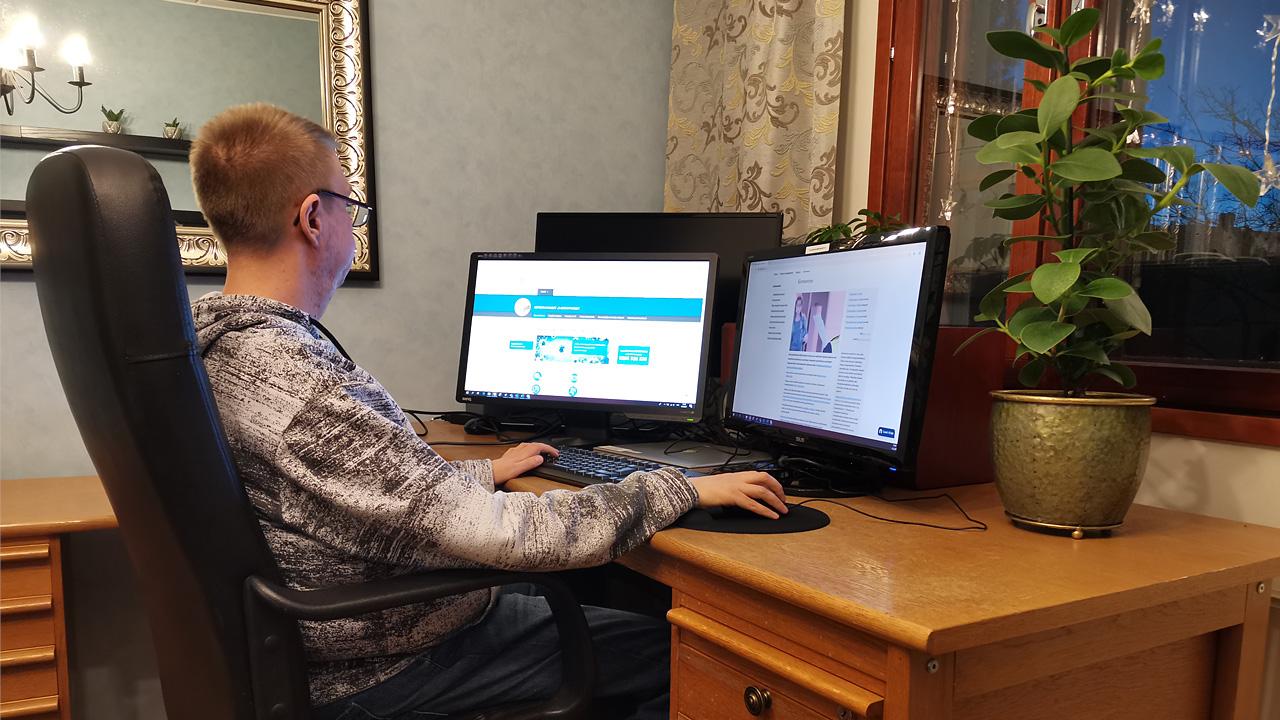 Mies istuu tietokoneella tekemässä töitä.