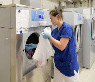 Alexandra Capatina sätter städtrasor i tvättmaskinen i sjukhusets städrum.