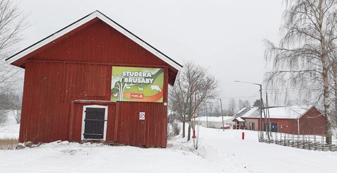 Vid infarten till Brusaby finns en röd lada med en affisch där det står: Studera i Brusaby.