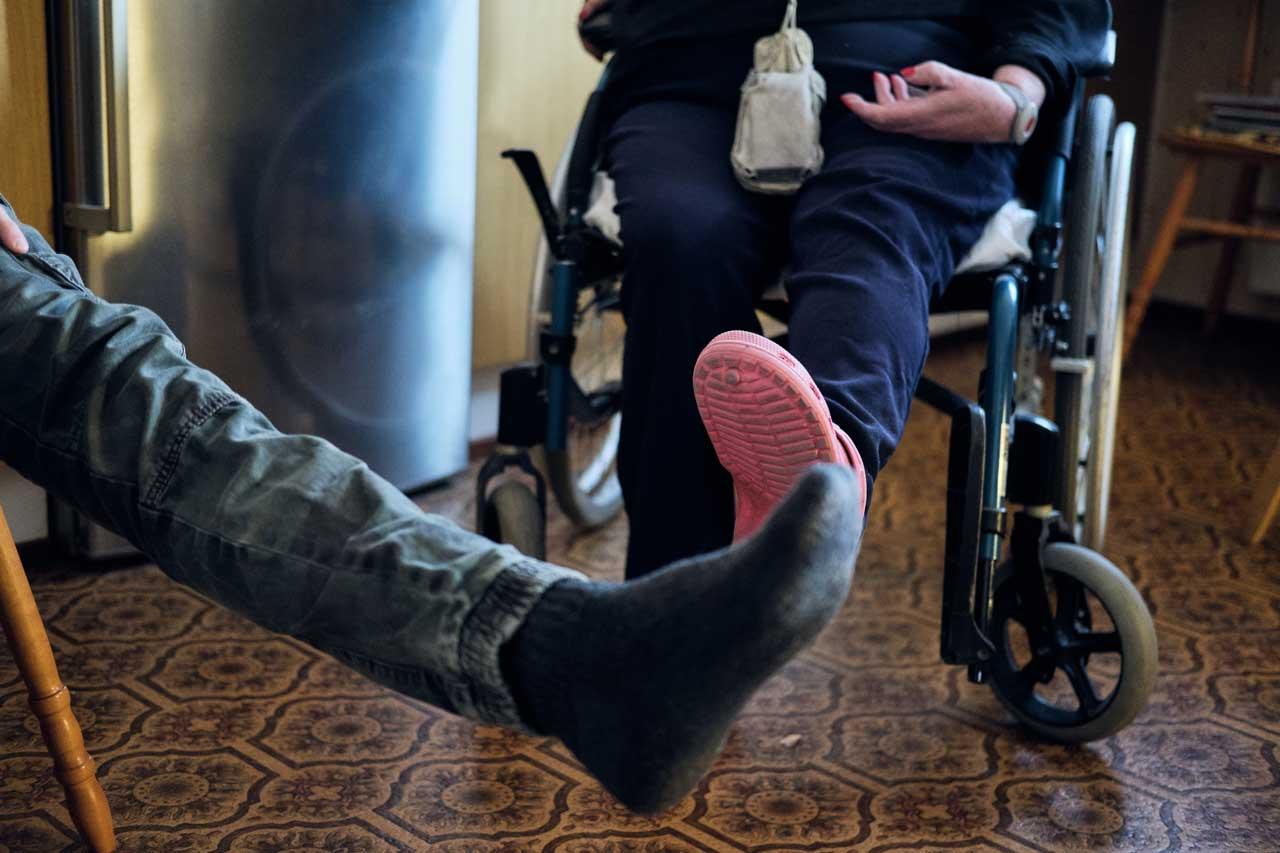 Lähihoitaja Nico Nordblad ja kuntoutettava Anne-Marie Påfs nostavat vasenta jalkaa vaakatasoon.