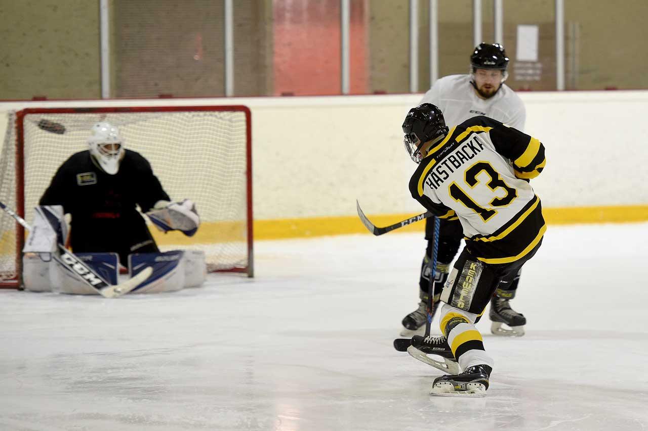 Los Bombers-spelaren Tony Hästbacka skjuter pucken i mål på en ishockeyträning.