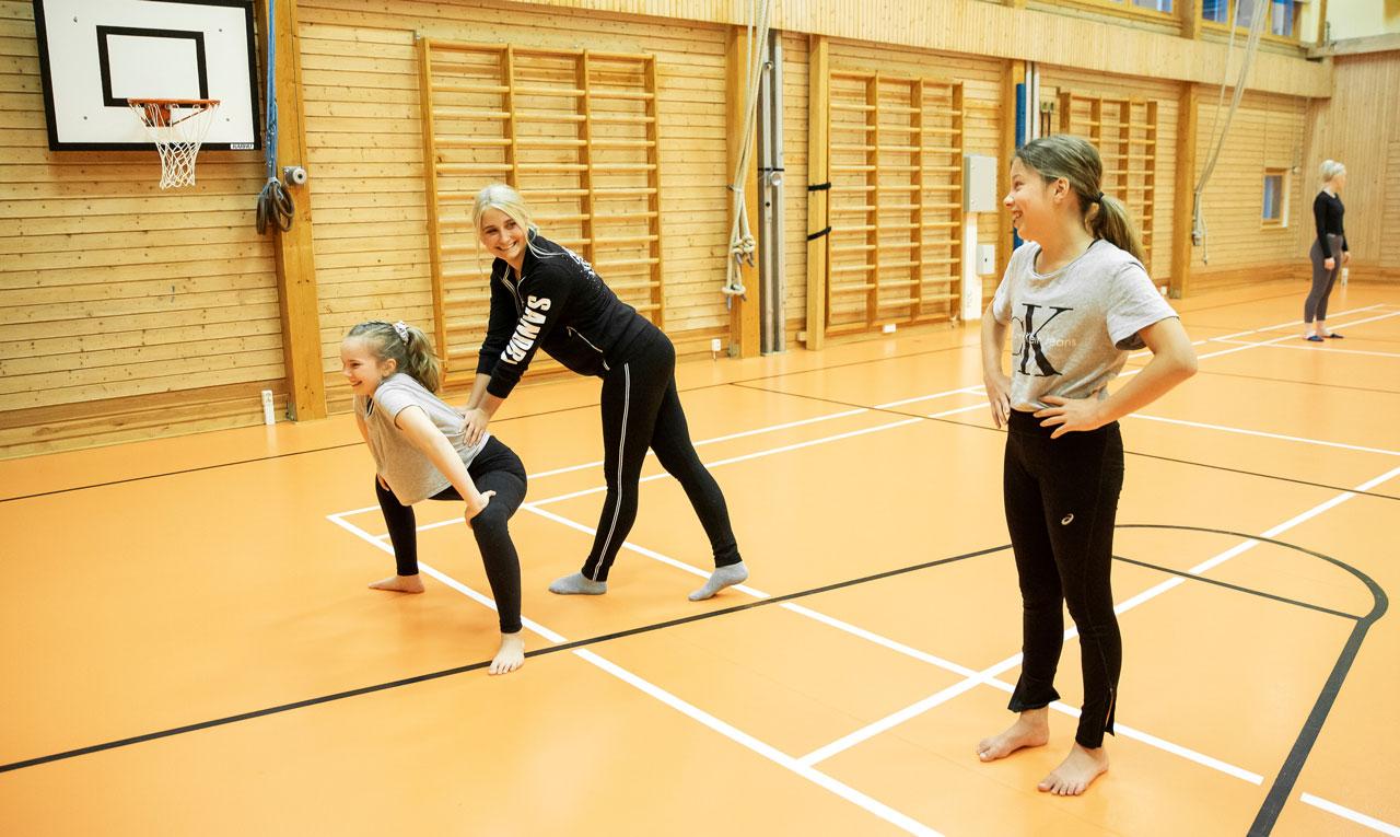 Elevassistenten och JHL-medlemmen Sandra Sirviö instruerar My Wennström och Vivian Keränen på Energy Dance Centers showdansträning.