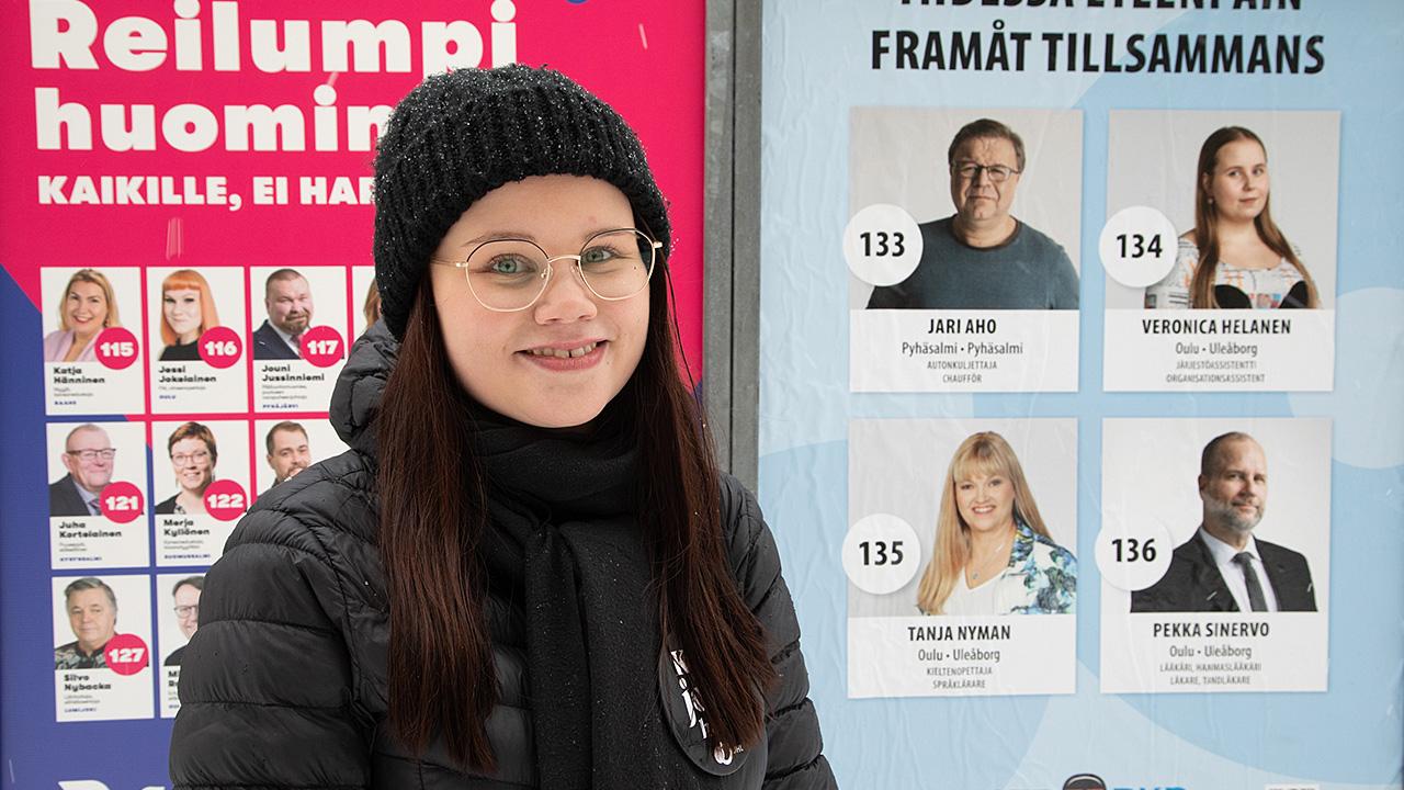 Ensi kertaa eduskuntavaaleissa äänestävä bioanalyytikko-opiskelija Laura Körkkö katsoo kameraan eduskuntavaalimainosten edessä Oulussa.