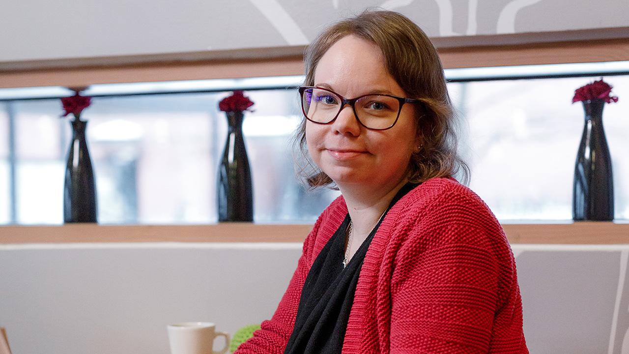 Kasvatustieteiden maisteri Hanna-Mari Nevalainen istuu Joensuun yliopiston kahvilassa.