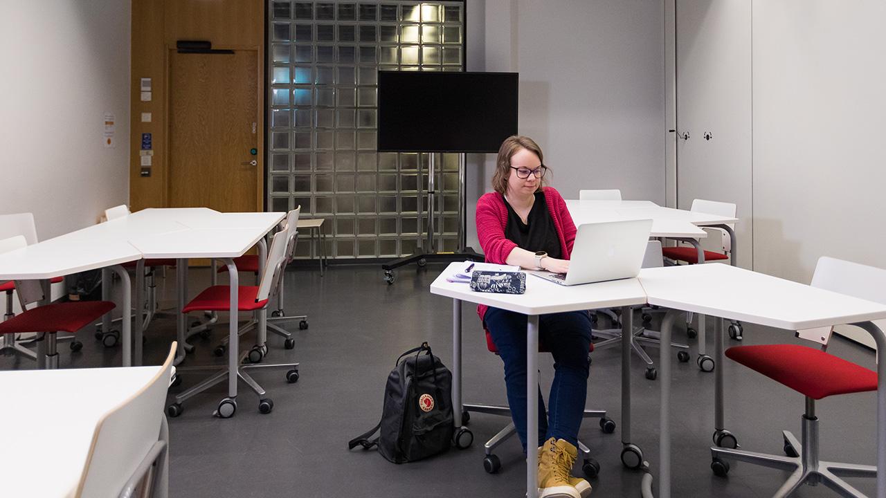 Erilainen oppija Hanna-Mari Nevalainen istuu tyhjässä luokassa Joensuun yliopistossa.