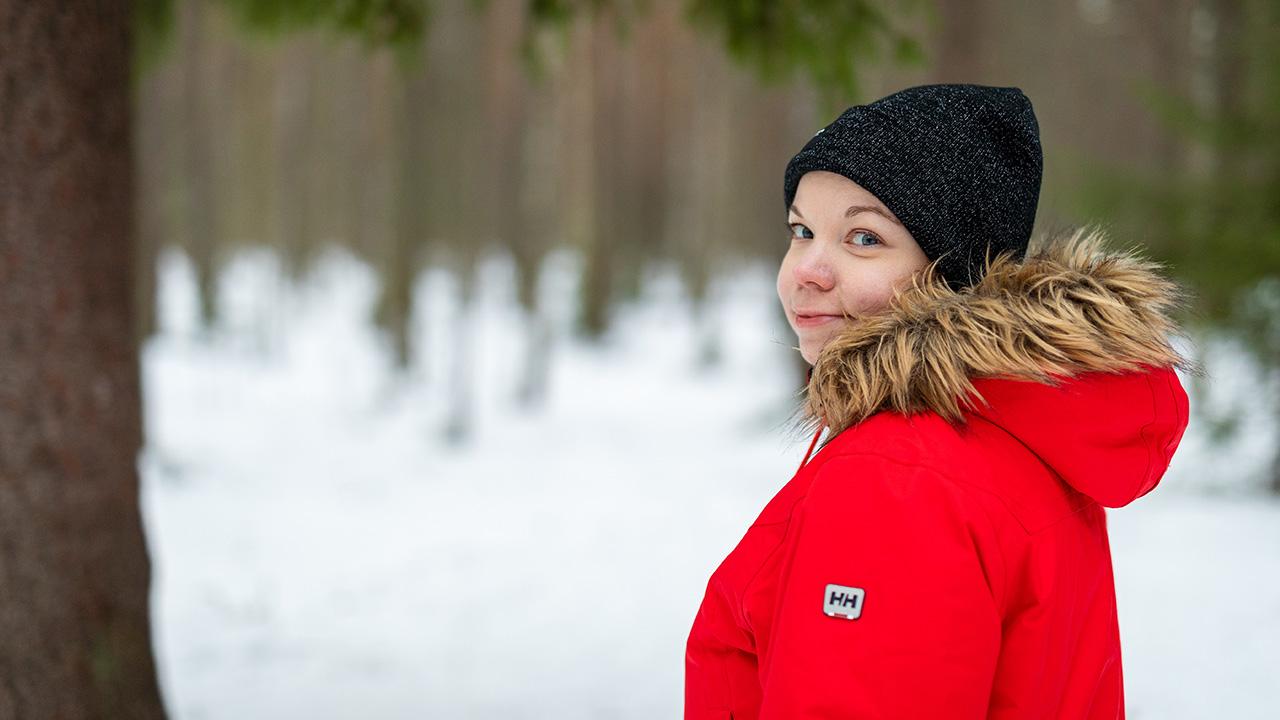 Erilainen oppija Hanna-Mari Nevalainen katsoo kameraan lumisessa metsässä Joensuussa.