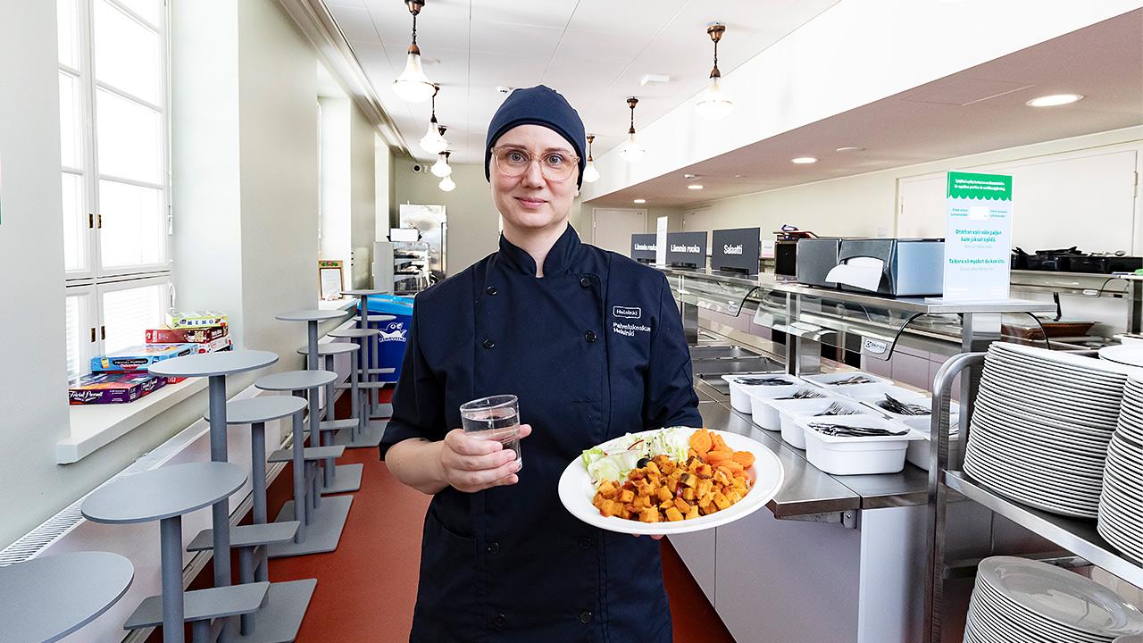 Kallion lukion kokki Marjo Niskanen esittelee ruoka-annosta keittiössä.
